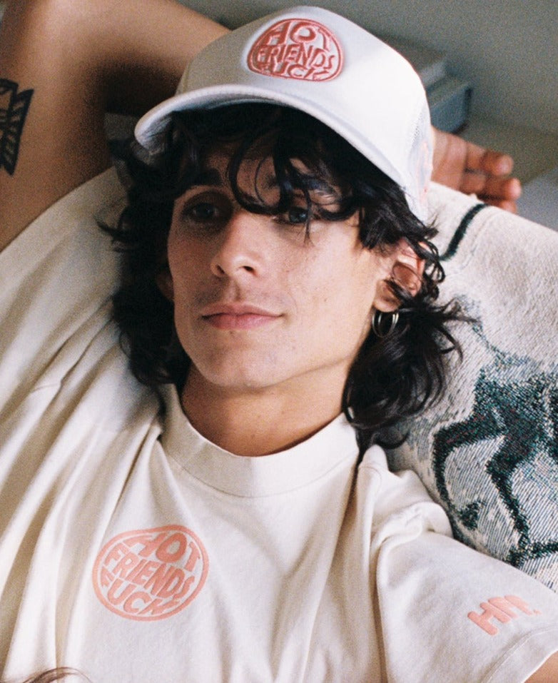 Donovan is wearing the Cream Hat with Salmon Pink Embroidery