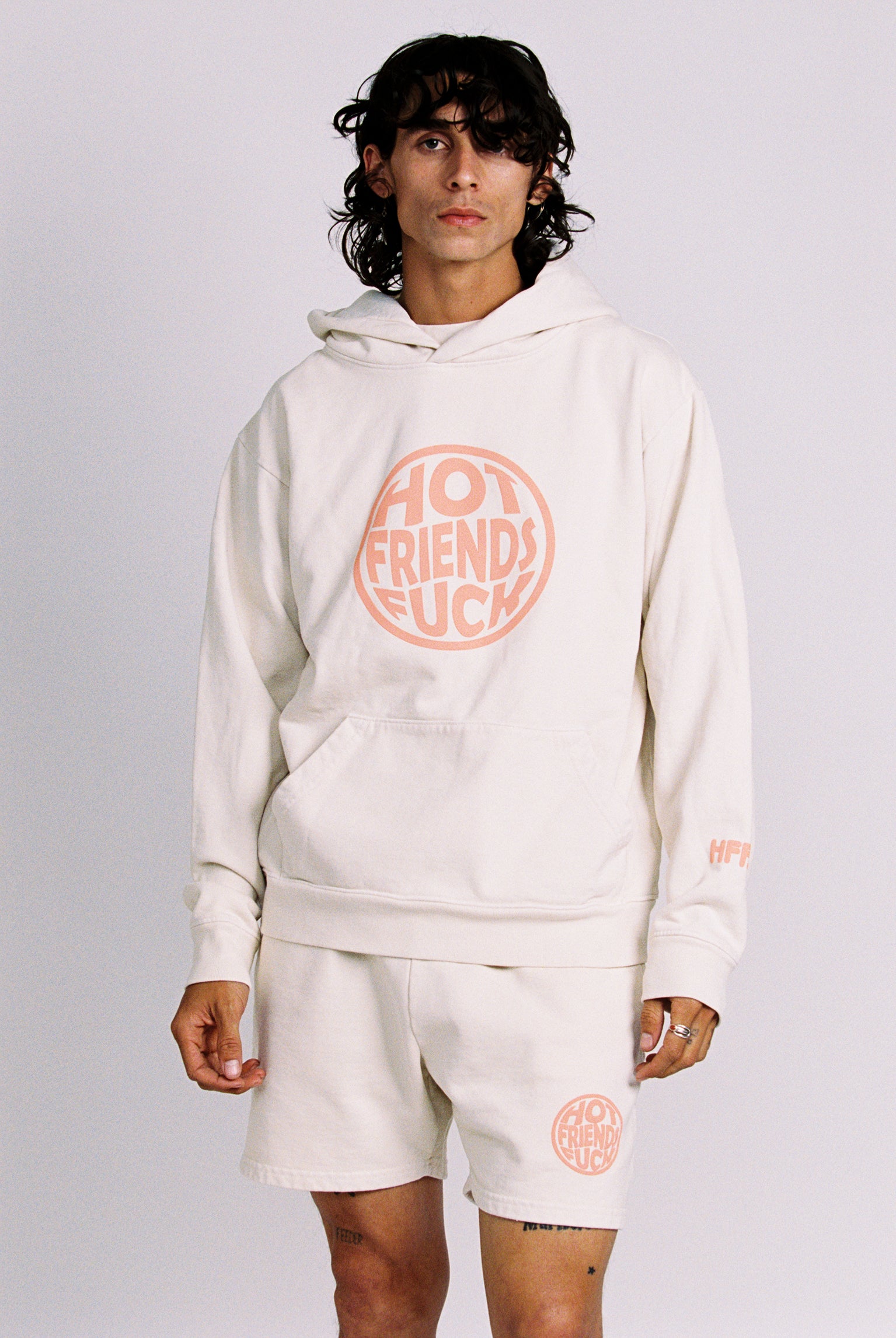 Donovan is wearing the Cream Hoodie with Salmon Pink Puff Print. 20oz French Terry