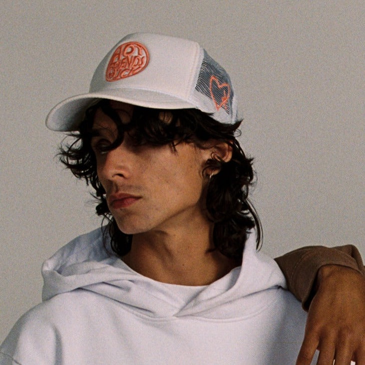 Donovan is wearing the Cream Hat with Salmon Pink Embroidery