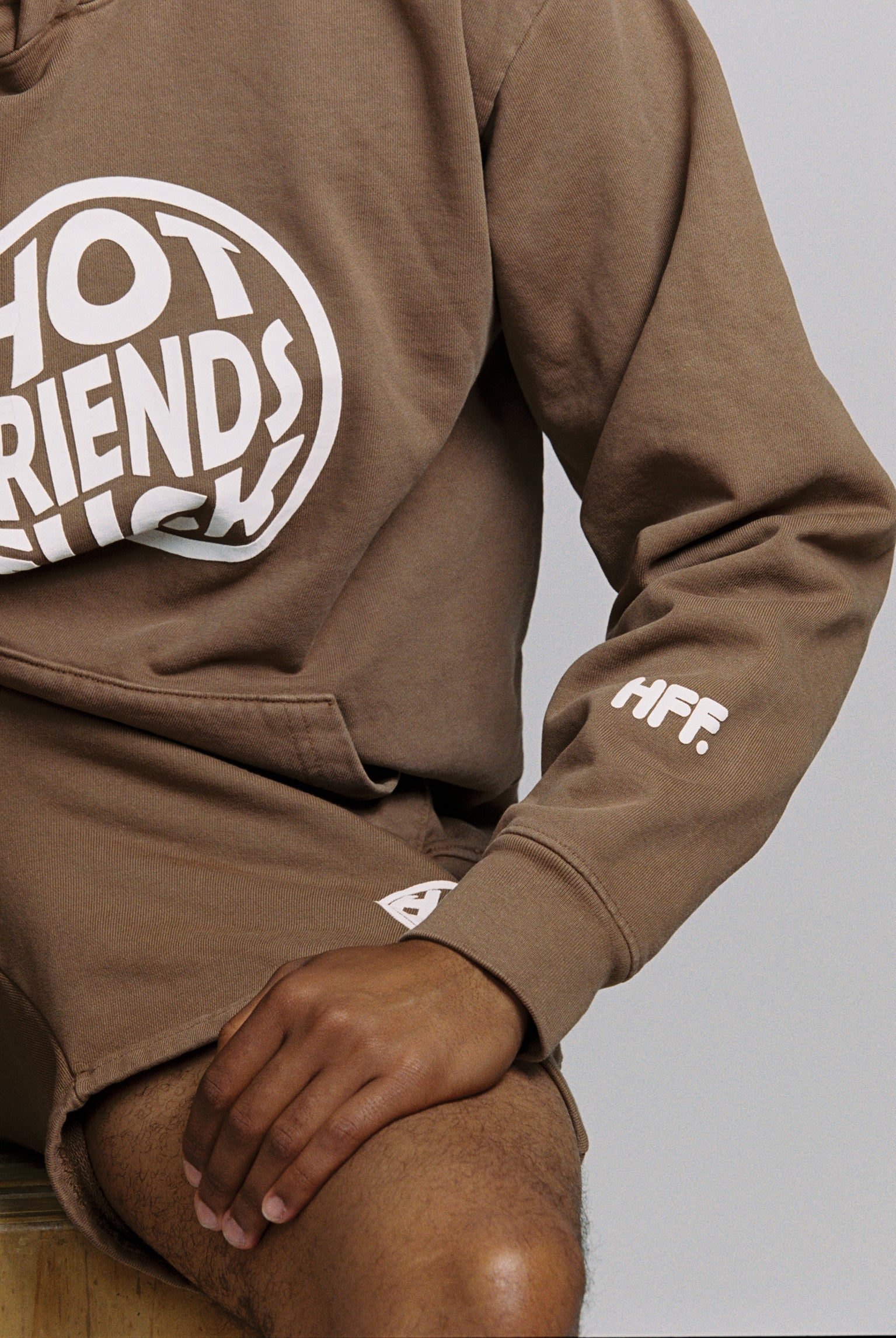 Hechan is wearing the Brown Hoodie with White Puff Print. 20oz French Terry