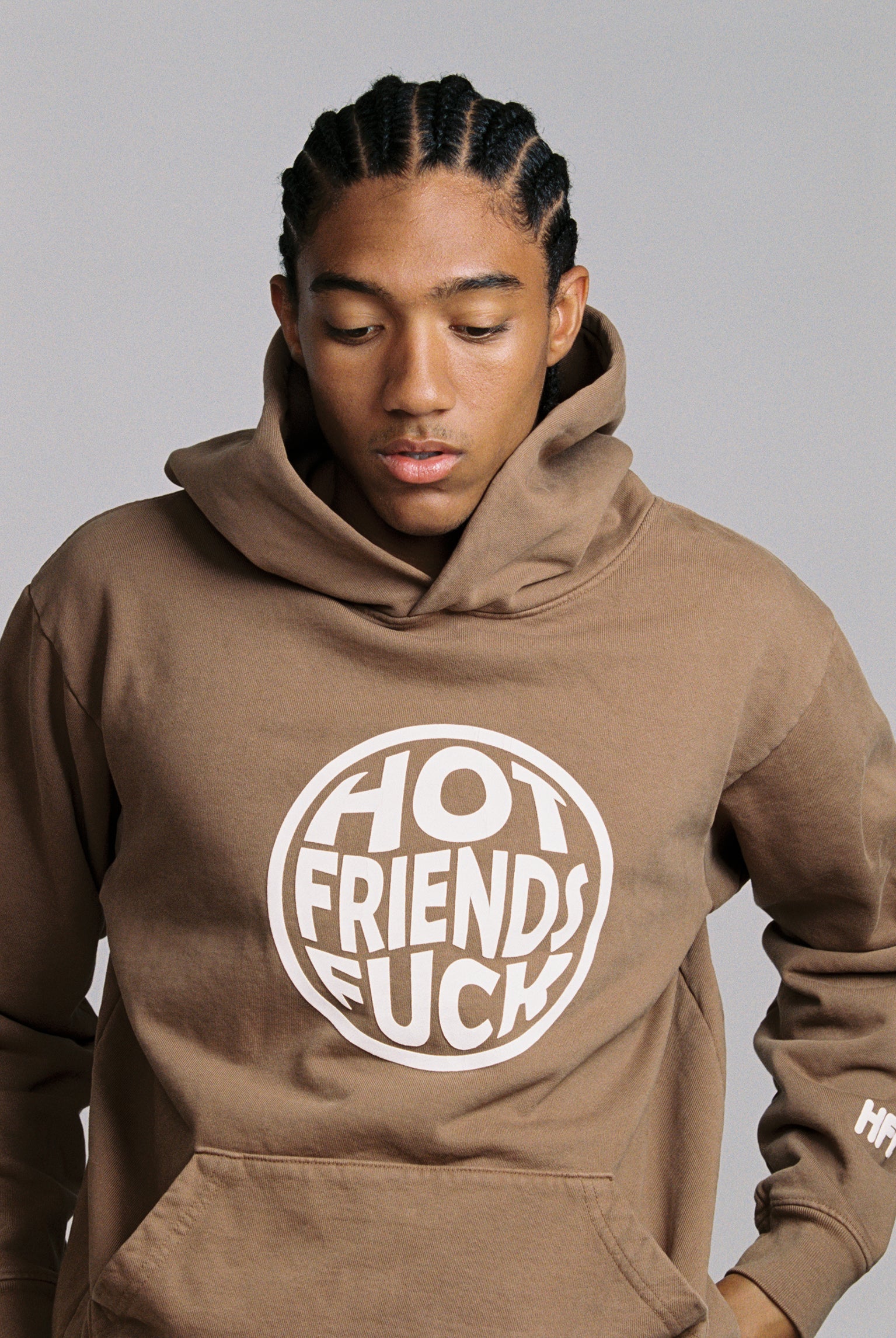 Hechan is wearing the Brown Hoodie with White Puff Print. 20oz French Terry