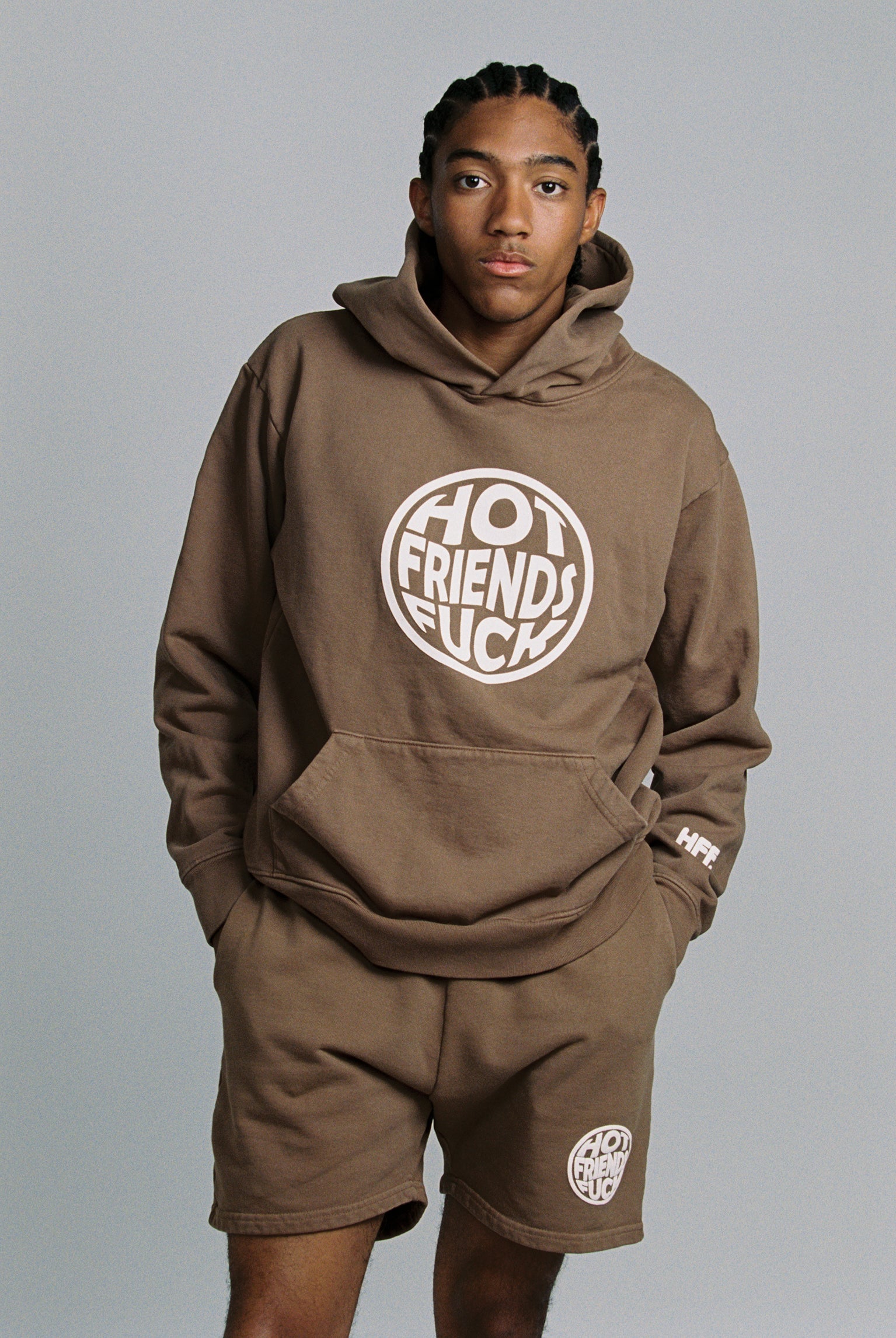 Hechan is wearing the Brown Hoodie with White Puff Print. 20oz French Terry