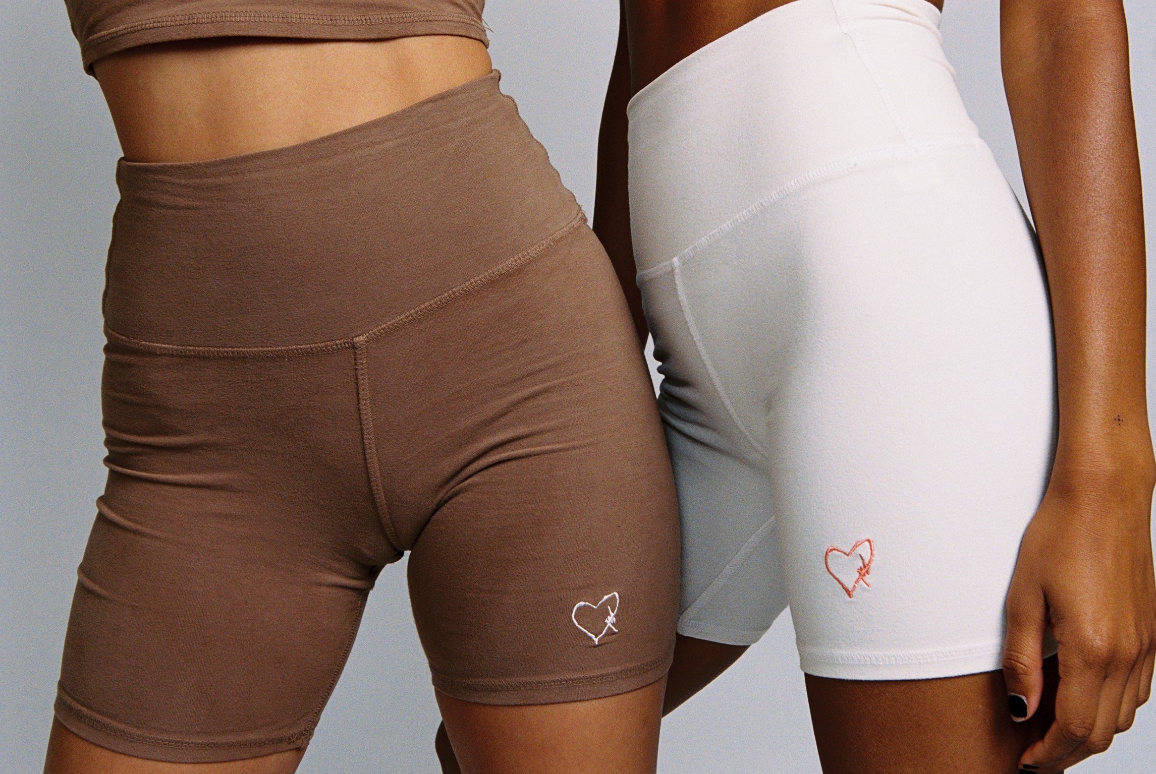 Sierra is wearing the Brown Biker Shorts with White Embroidery, and Maddie is wearing the Cream Trucker Shorts with Salmon Pink Embroidery