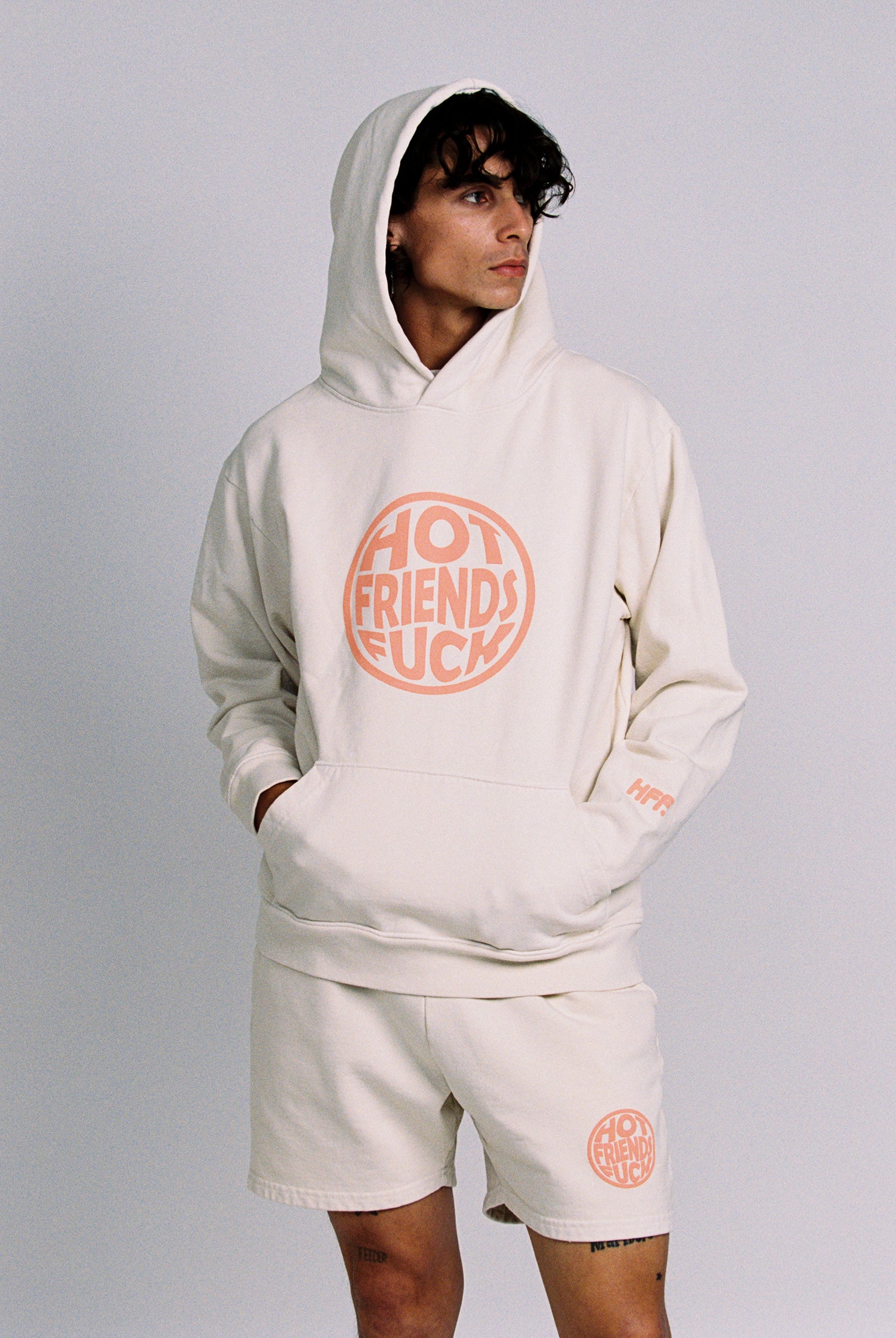 Donovan is wearing the Cream Hoodie with Salmon Pink Puff Print. 20oz French Terry